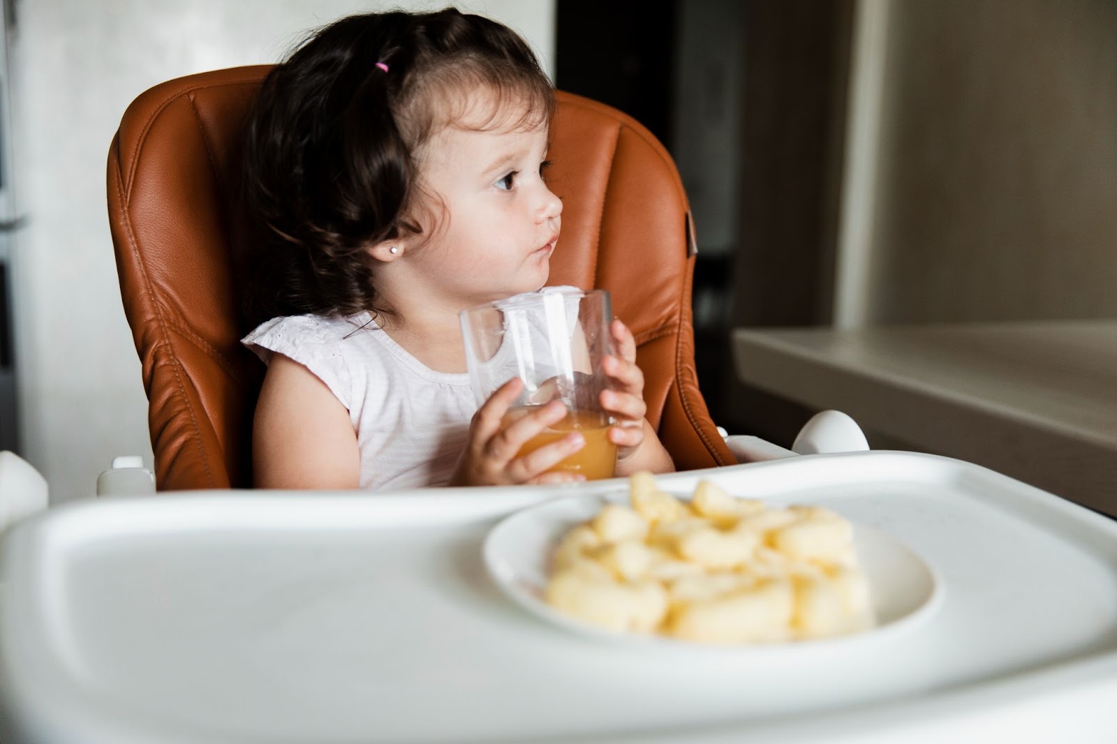 A little girl drinking a glass of juice