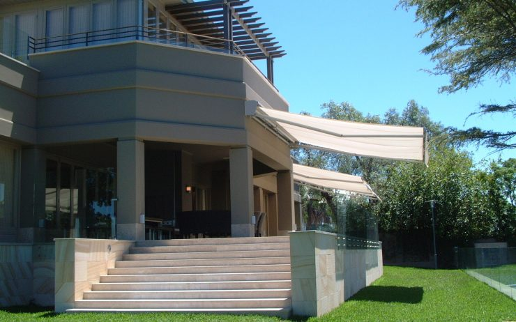 white folding arm awnings extending in the front porch providing shade from the sun