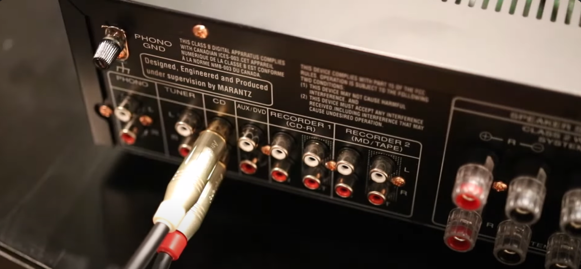 Marantz audio receiver with a phono ground terminal and an RCA cable connected to the CD input.