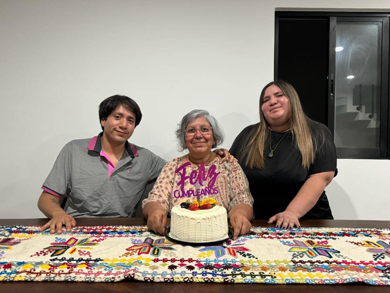 Un grupo de personas frente a un pastel de cumpleaños

Descripción generada automáticamente