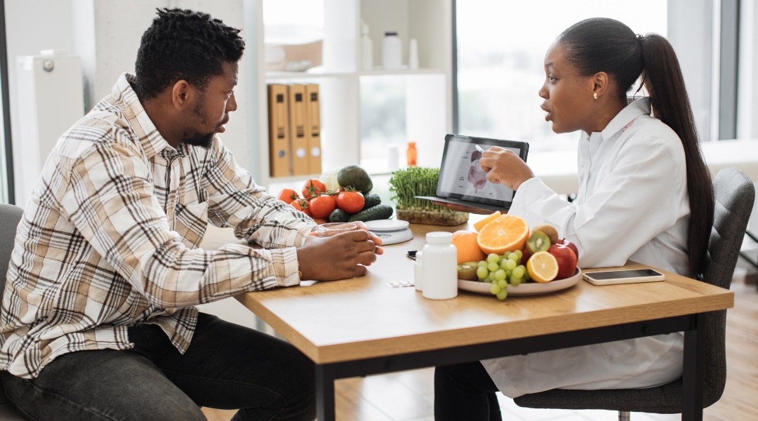 Toronto Nutritionist Dietitian holding a tablet displaying the gastrointestinal tract while advising a client.