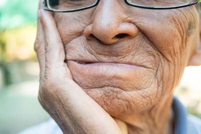 Close up view of the lower half an older adults face with a sunken in mouth