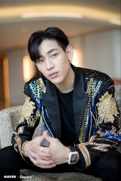 A picture of Bambam sitting on a hair, wearing a blazer 