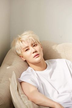 This contain an image of Kim Junsu laying on top of a couch