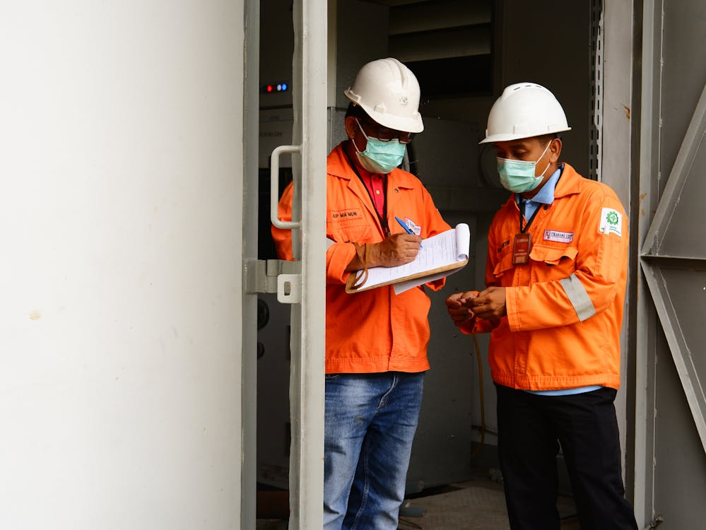 Workers using manual checklist highlighting challenges of incident management in the field.