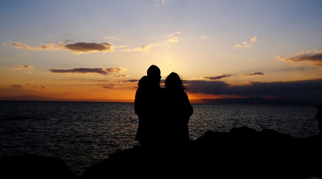 夕日の海に立つ女性

自動的に生成された説明