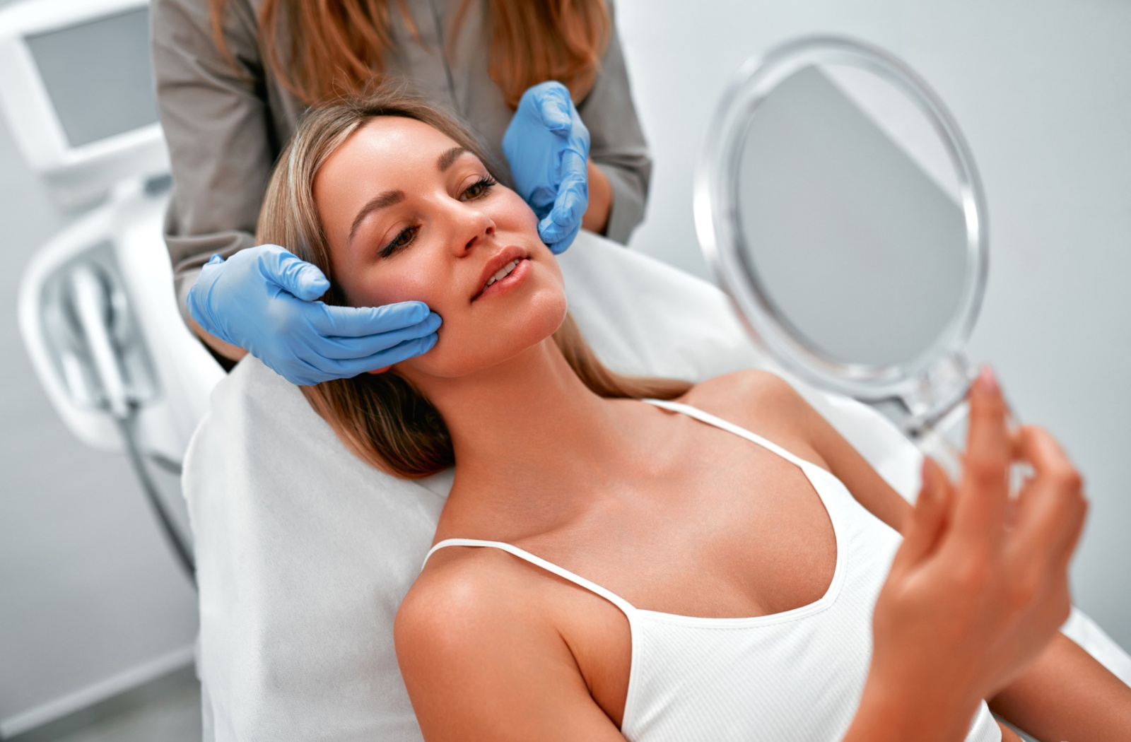 An adult sits with their skincare provider during a consultation, discussing how to approach treatment for their skin concerns.