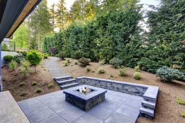 fire pit area designs for your northern michigan backyard stone fireplace with built in seating and surrounding greenery custom built boyne city