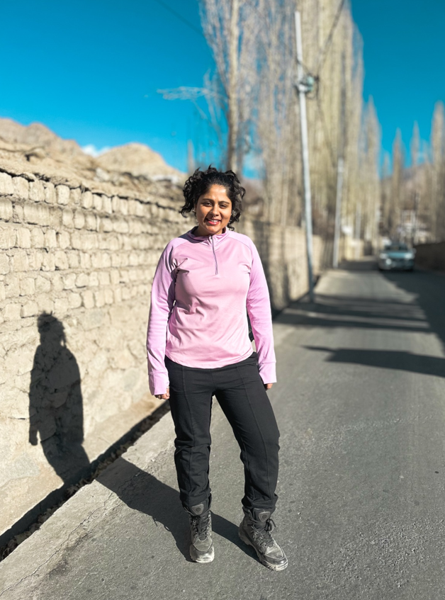 Traveler wearing Kosha Merino wool base layer top and winter pants in cold dry Leh weather, demonstrating warm clothing for winters with natural winter fabrics