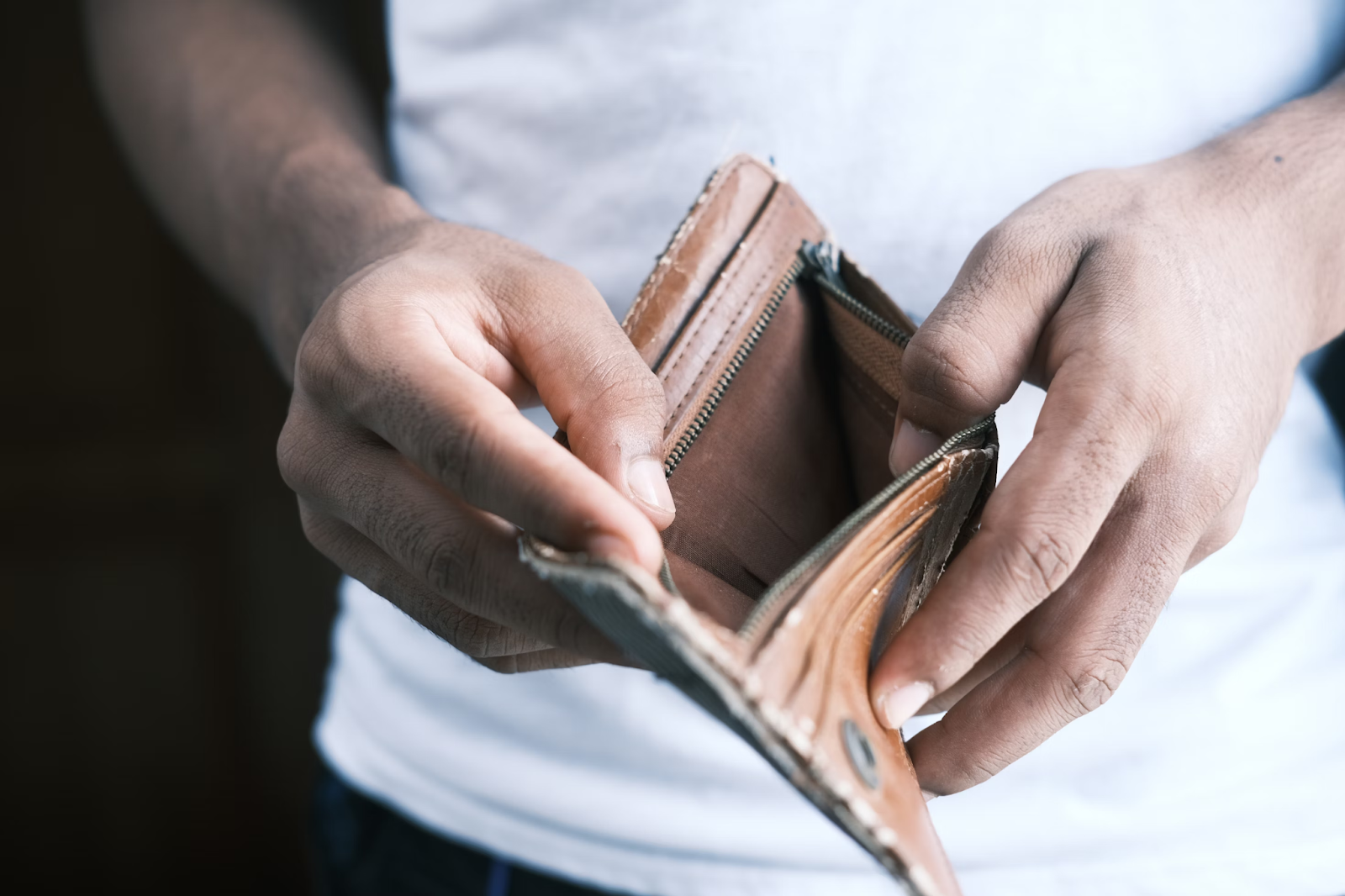 Hands holding an empty brown wallet 