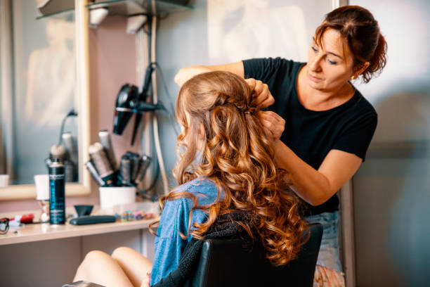 Hairdresser styling hair with heat — a reminder to use protectants to prevent split ends and hair breakage.