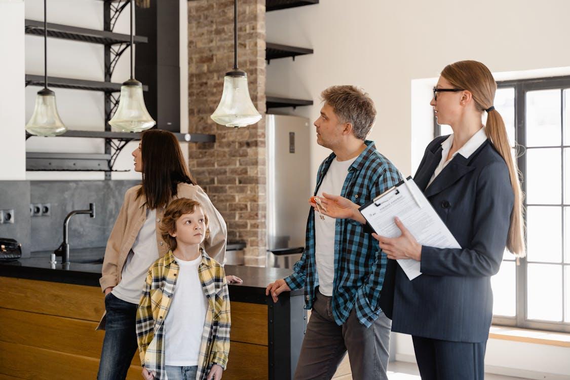 Free A family converses with a real estate agent about a modern home interior. Stock Photo