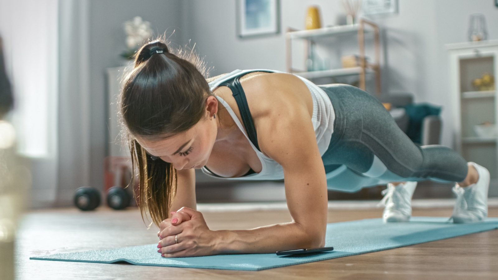 A woman is seen performing plank,