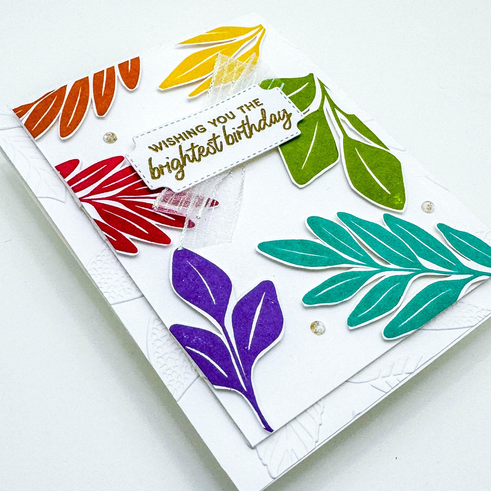 A card with colorful leaves and a tag

Description automatically generated