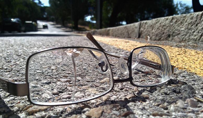 Isolated broken glasses left on the road on a sunny summer day