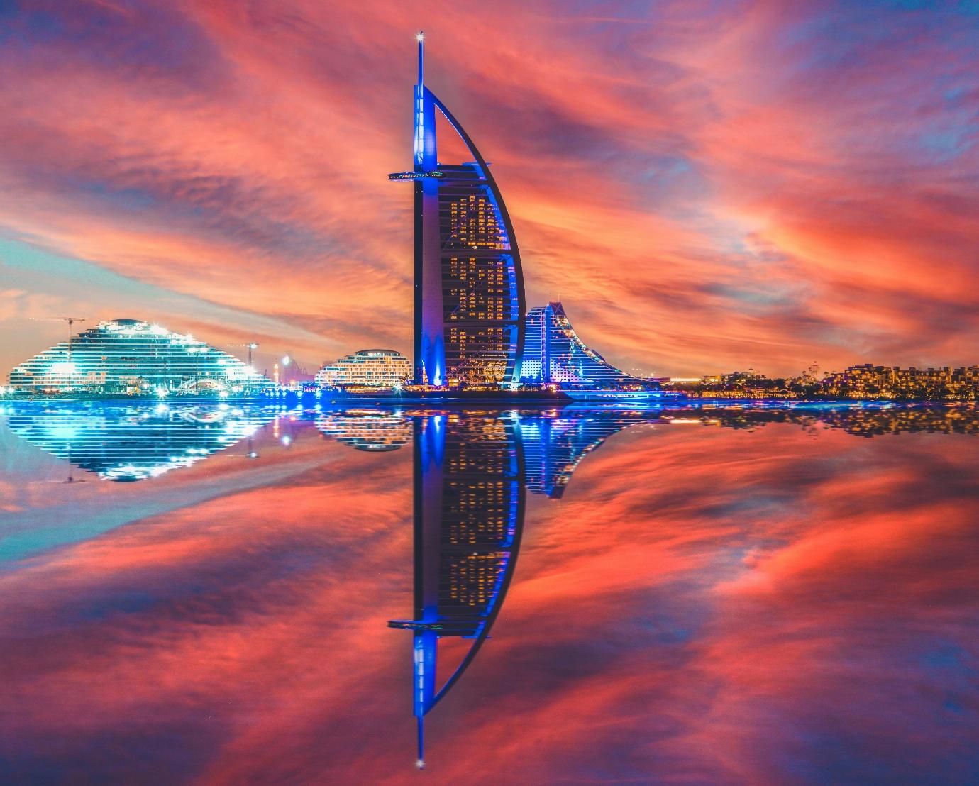 A dubai city skyline with a reflection of a sunset

