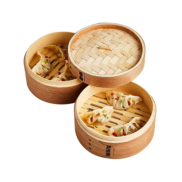 A traditional two-tier bamboo steamer filled with freshly steamed dumplings, with the woven lid resting on top.