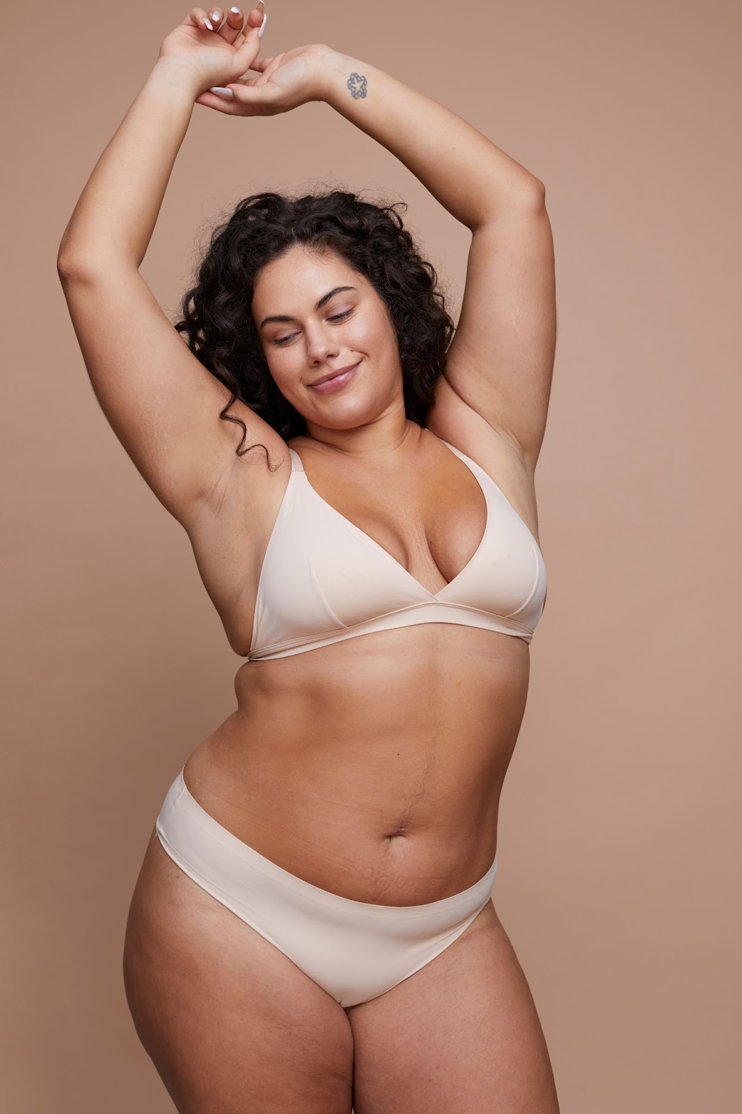 Plus size woman wearing nude bra and panty set.