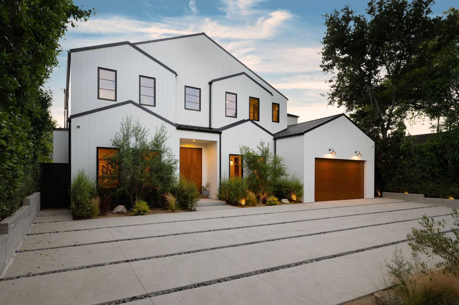 A modern luxury home with a concrete driveway. 