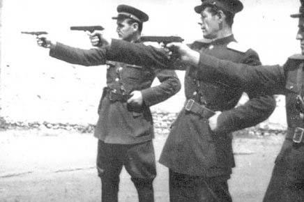 A group of men in uniform holding guns

Description automatically generated