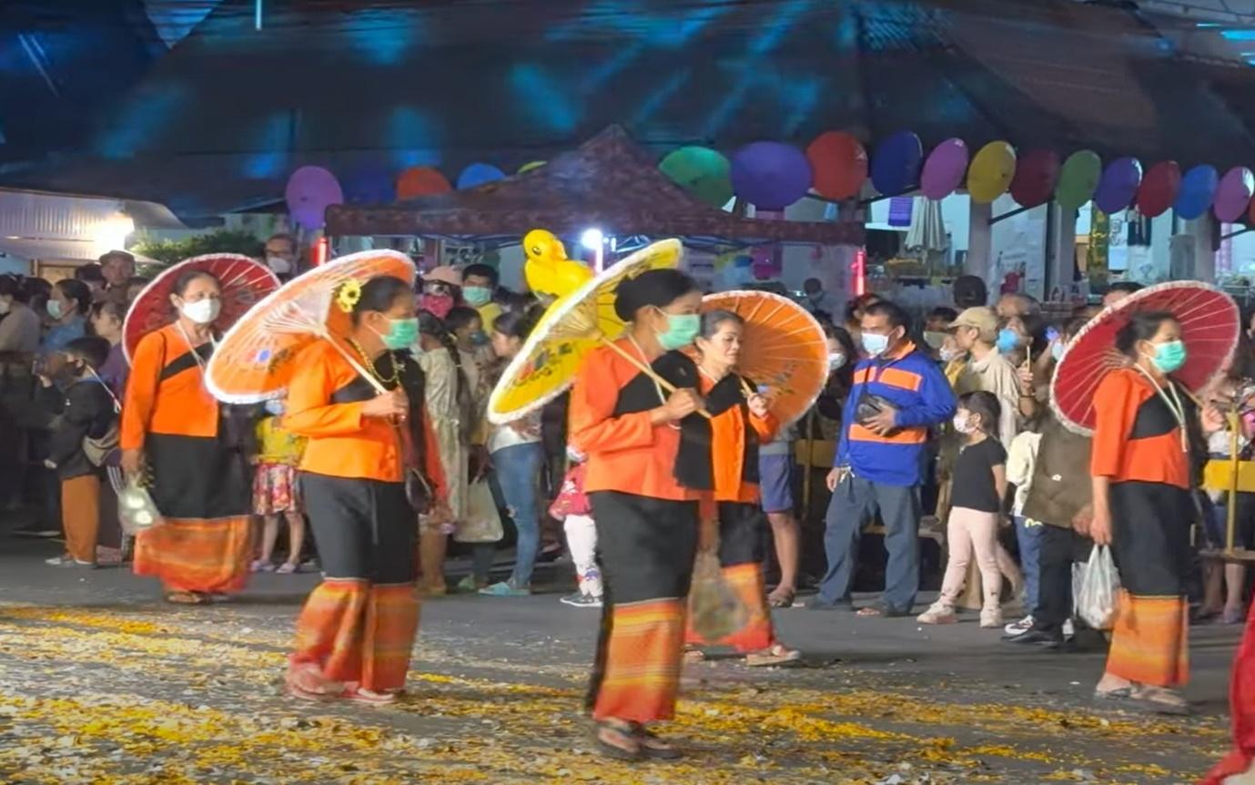 A group of people walking with umbrellas

Description automatically generated