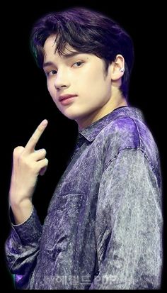 This  contain an image of the Hueningkai wisdom posing with his finger up in front of him and wearing a purple shirt