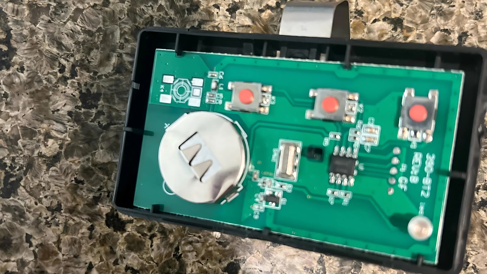 Circuit board exposed in garage door remote.