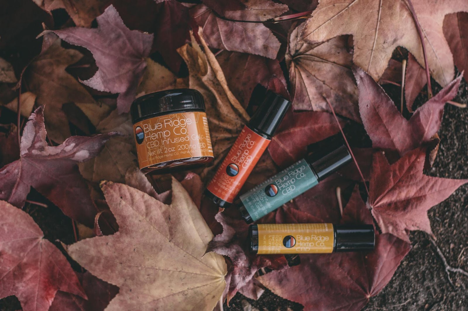 CBD products nestled among autumn leaves, showcasing natural skincare options in a fall setting.