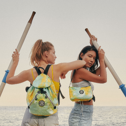 Two women holding poles in front of water

Description automatically generated