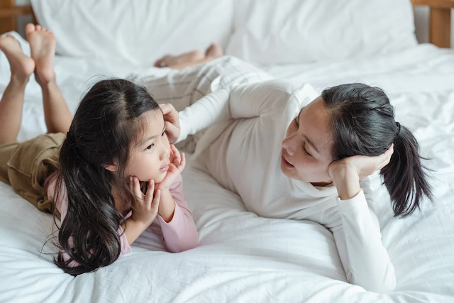 Mother and a child lying on a bed