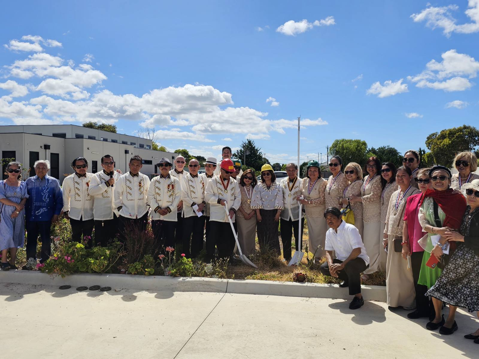 A group of people standing in front of a buildingDescription automatically generated