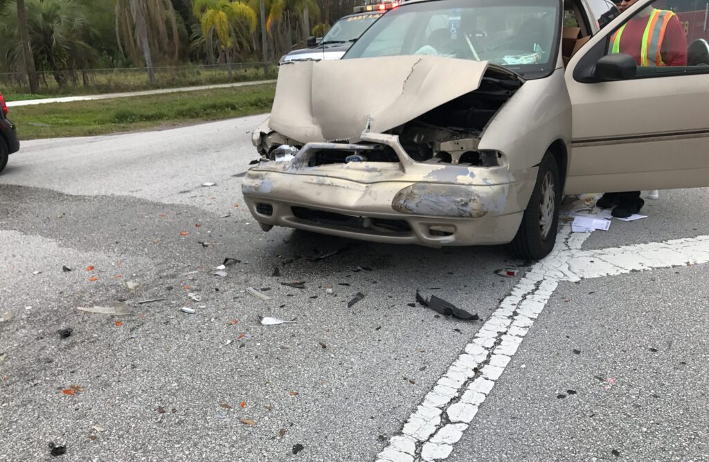 The damaged front end of a minivan after a speeding accident.