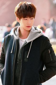 This contains an image of Song Jae Rim's wearing a black and grey hoodie