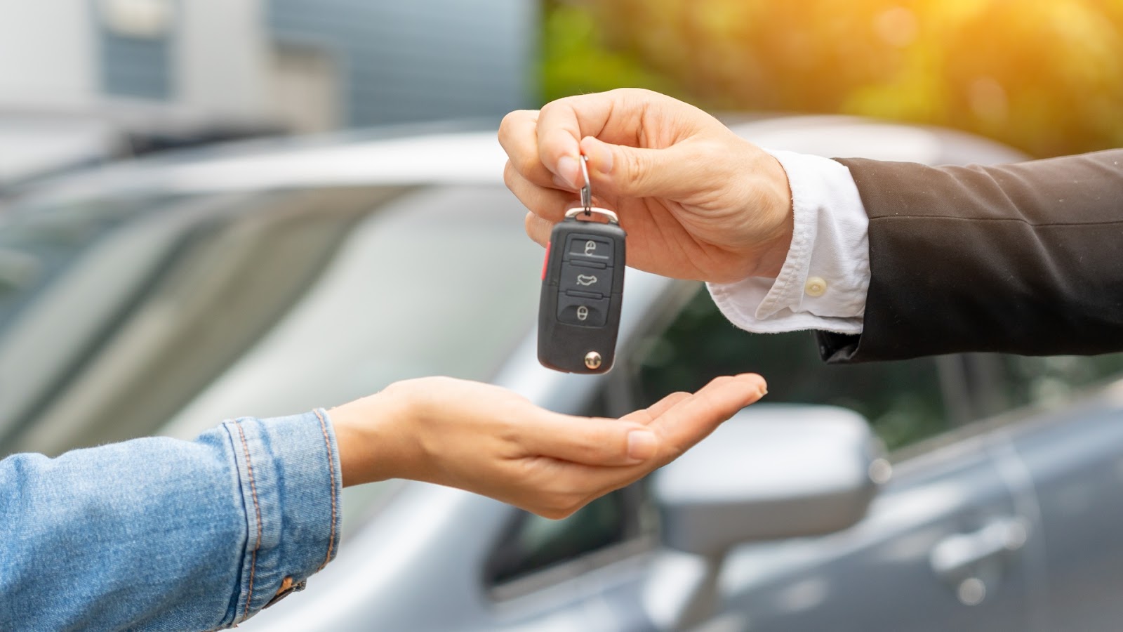 A car owner receiving a key fob from a professional locksmith.