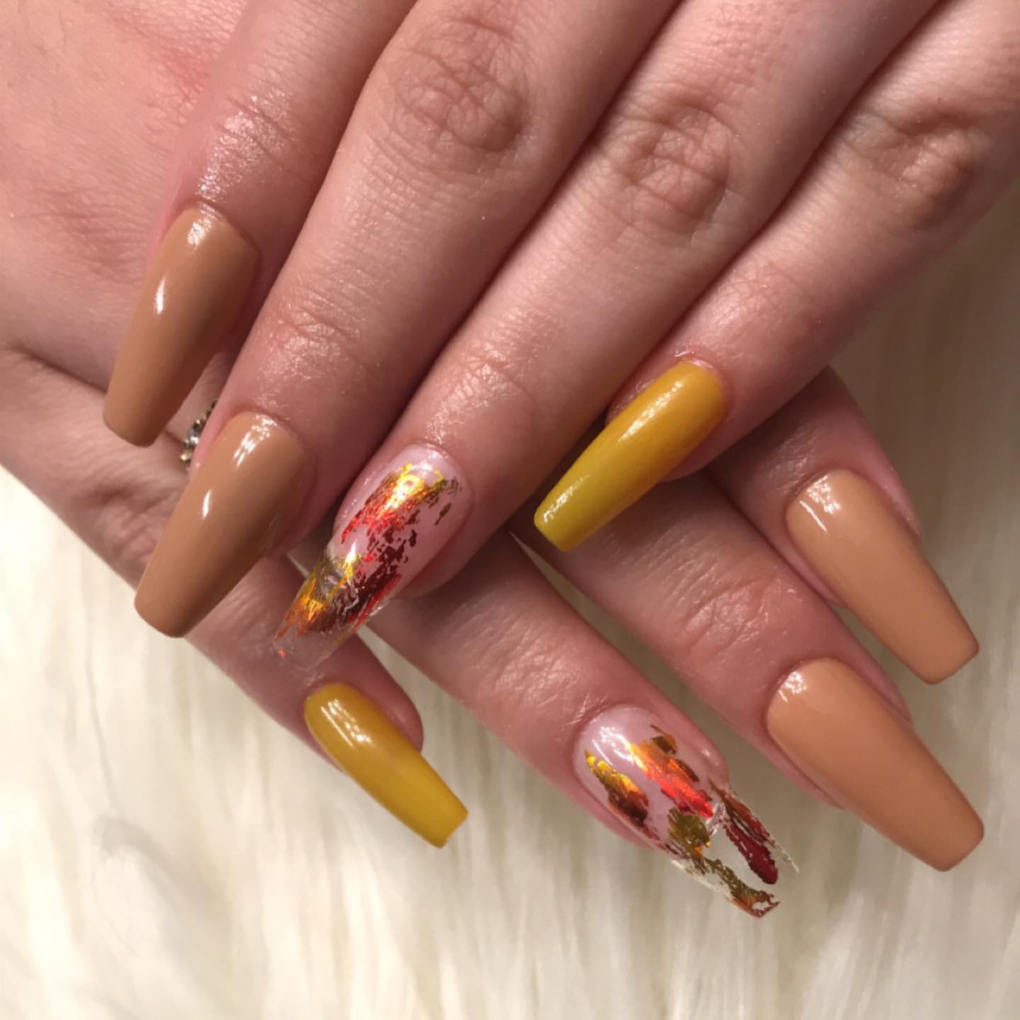 Close-up of hands with fall nail design having Coffin Shape with Fall-Inspired Art