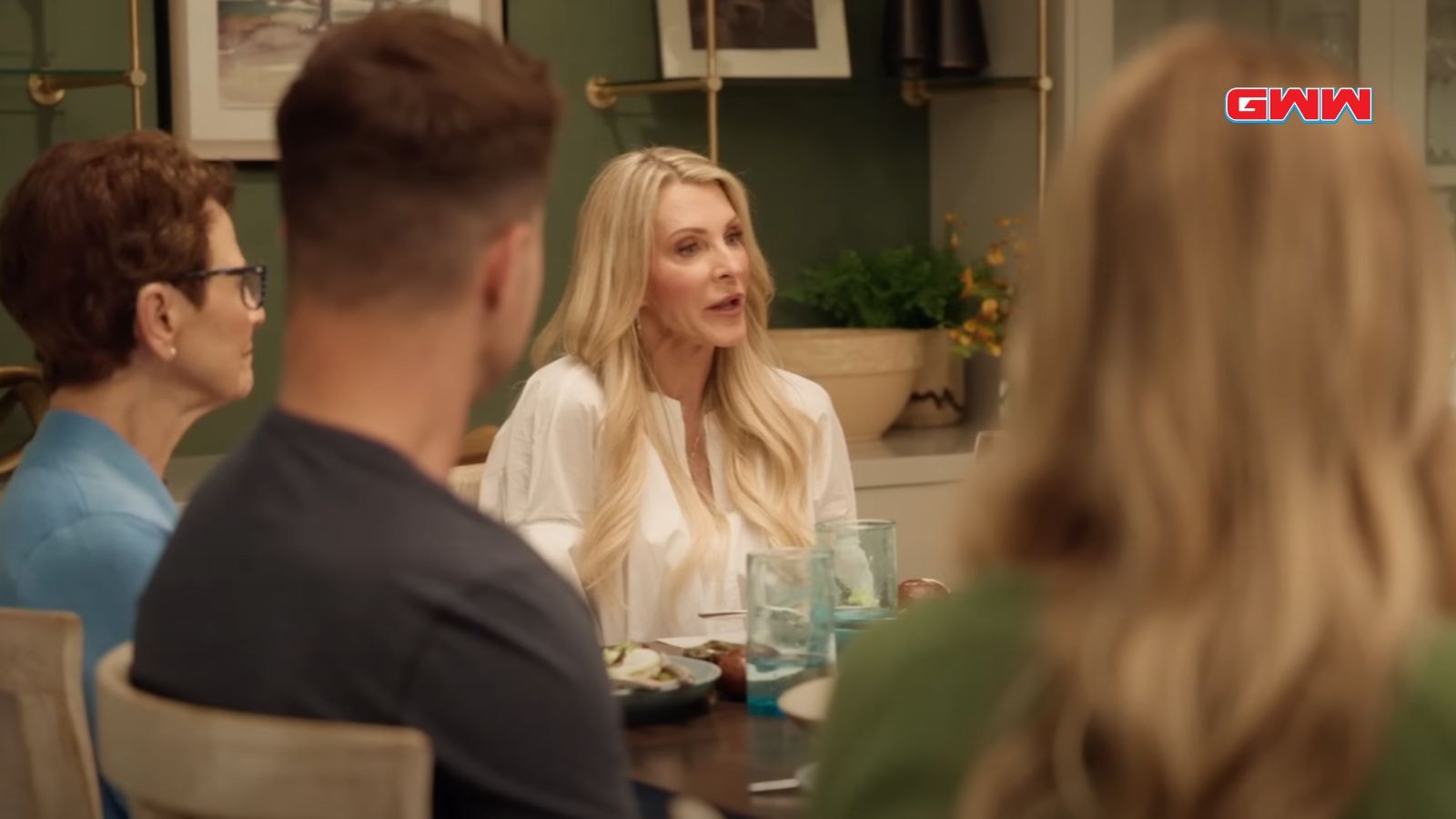 Group of people having a conversation around a dinner table.