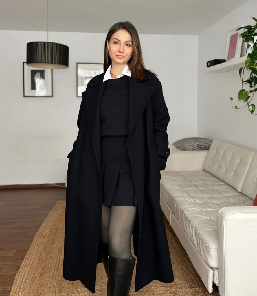 A black wool coat, sweater and tennis skirt.