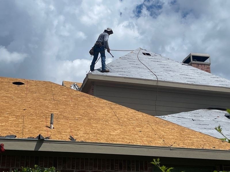 a worker from Pickle Roofing Solutions doing roof underlayment