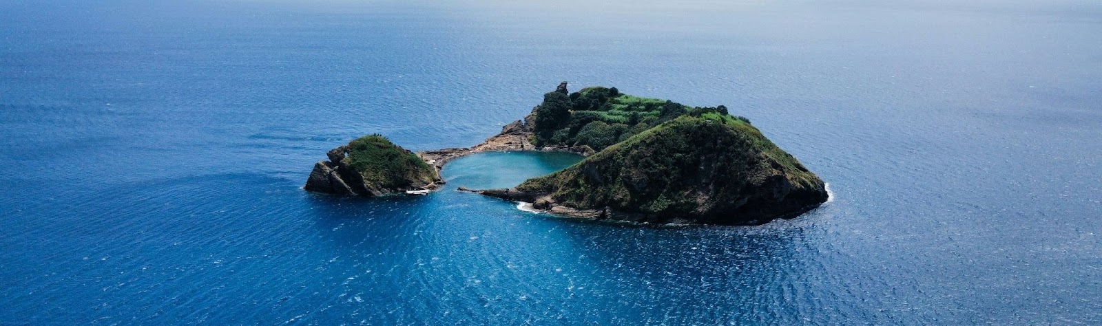 Imagem aérea do Ilhéu de Vila Franca do Campo cercado por águas azul-turquesa, ponto turístico famoso de onde fica a Ilha de São Miguel, em Portugal.