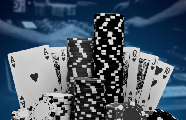 Black and white casino chips and playing cards arranged on a table, representing the classic elements of online gambling NZ and traditional casino games.