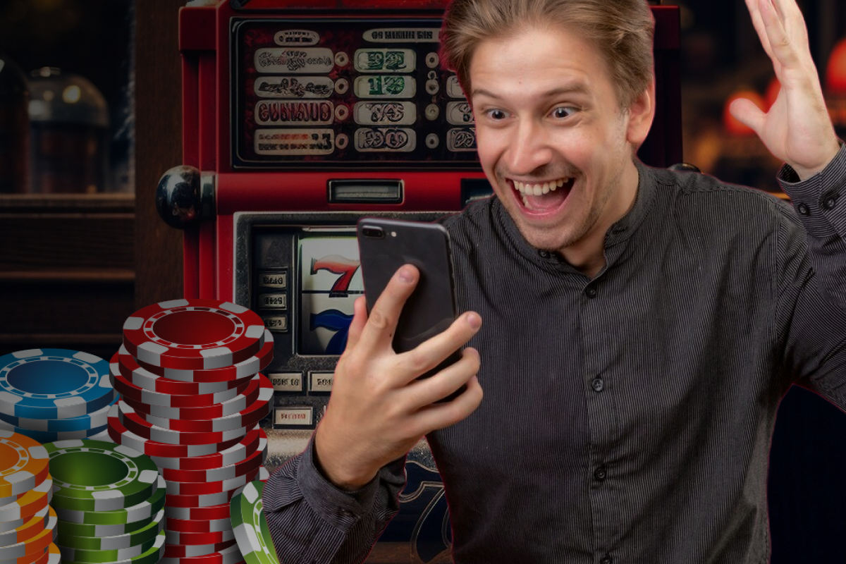  Hombre sosteniendo su teléfono mientras juega en un casino, mostrando concentración y emoción en su rostro.