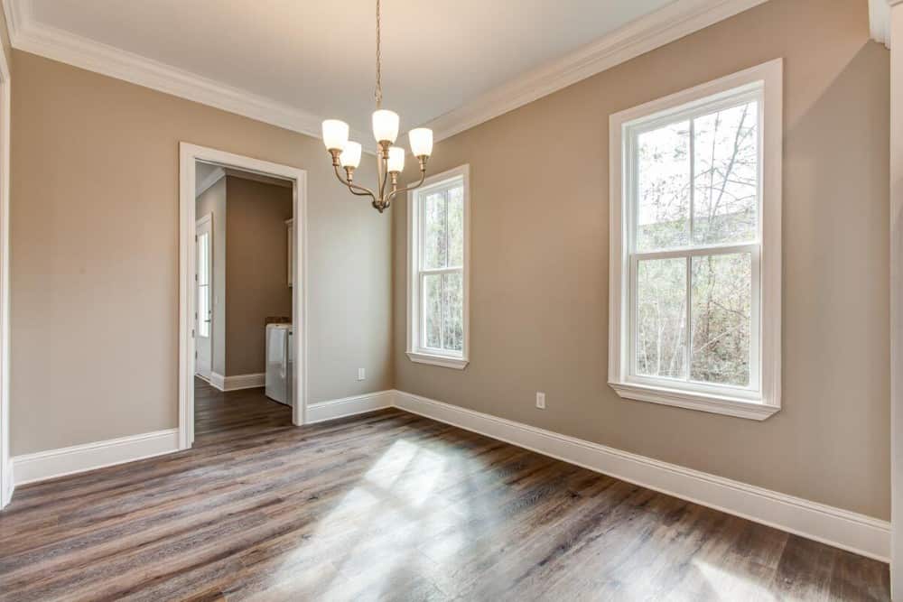 Bedroom with hardwood flooring and white framed windows that invite natural light in.
