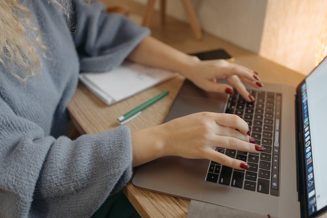 Free Person Typing on a Macbook Stock Photo