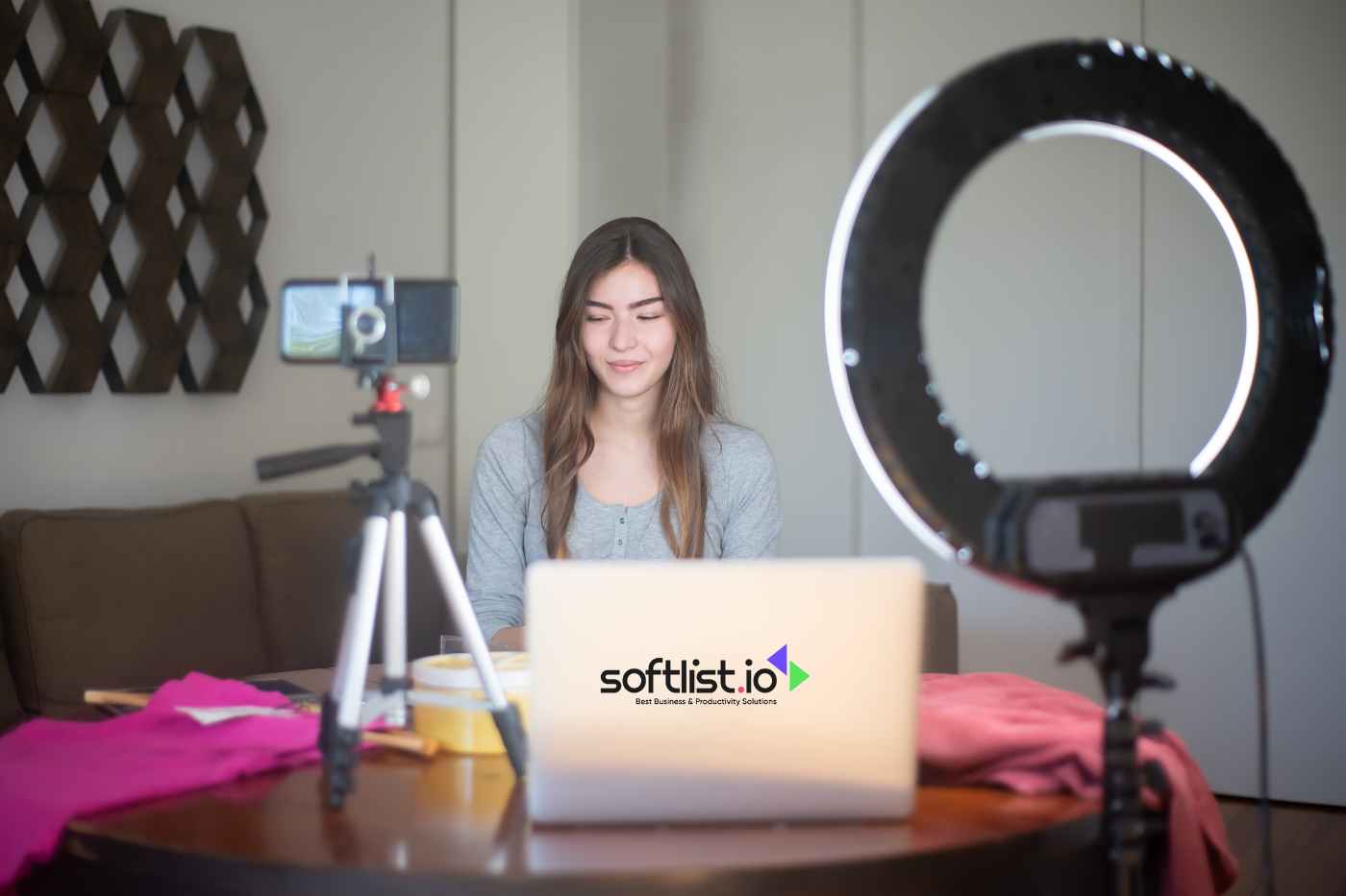 a woman with laptop, ring light, and a phone