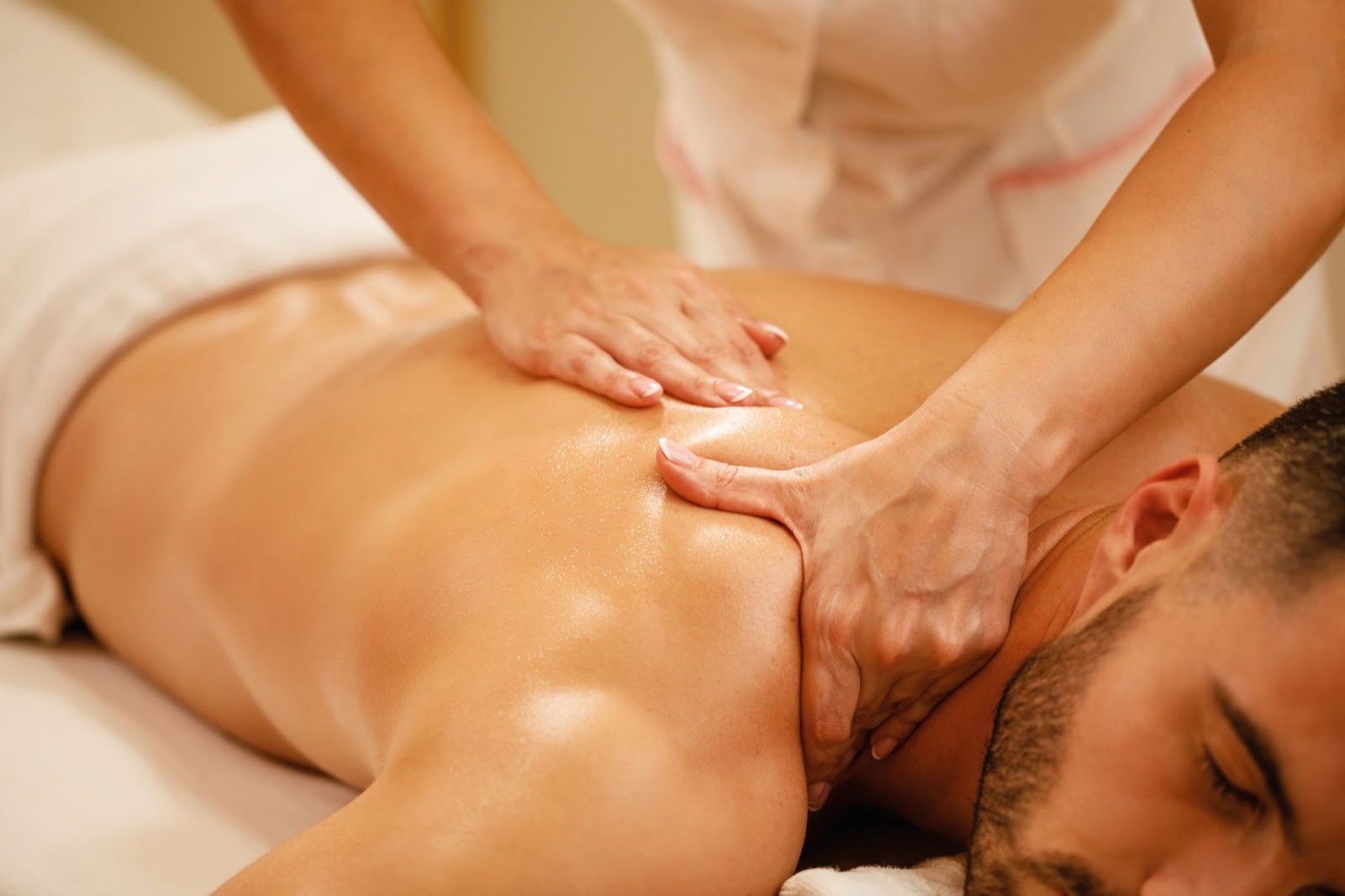 A man gets a massage while lying on a table.