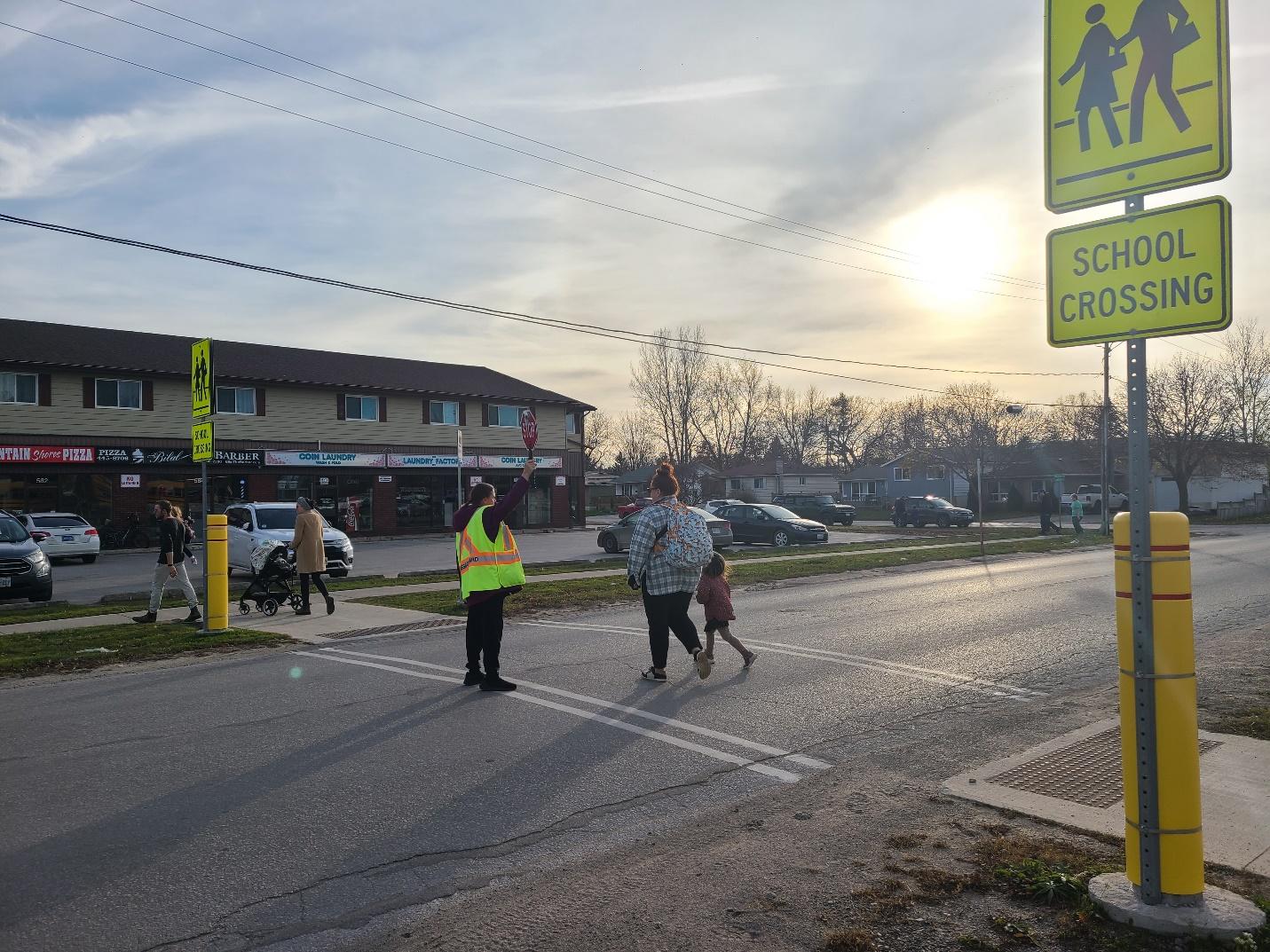 A group of people crossing a street

Description automatically generated