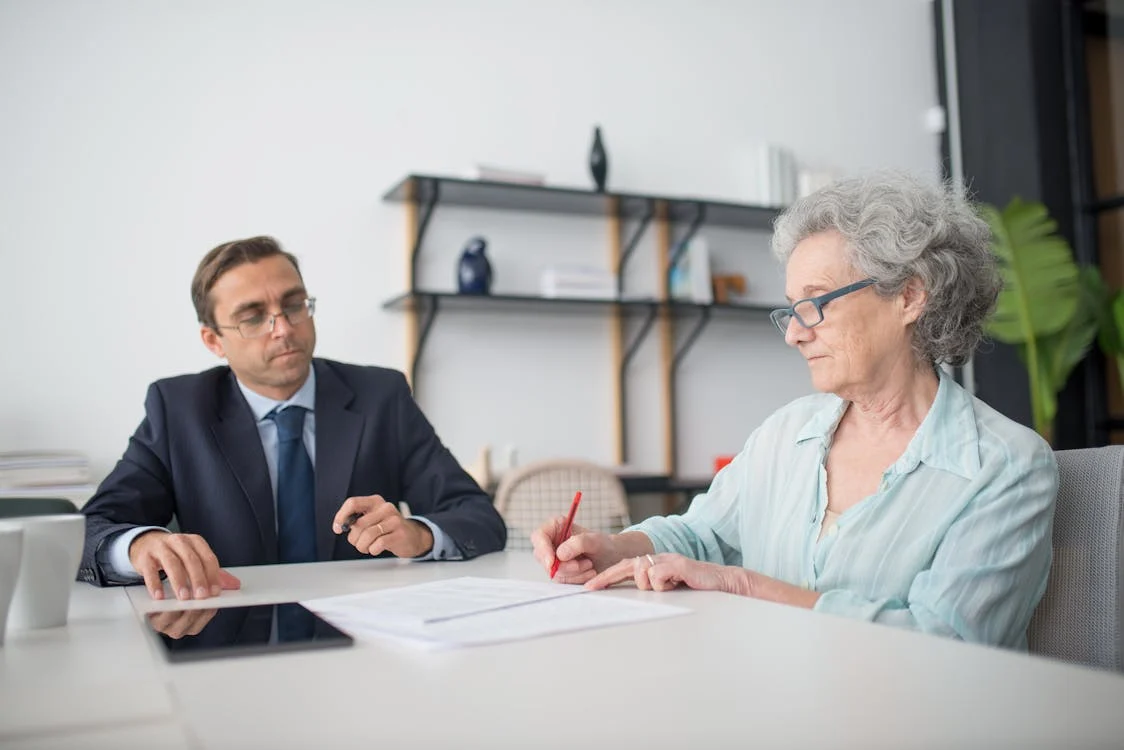 A woman and a man signing papers in an office