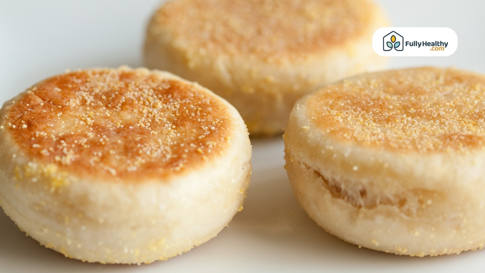 Toasted plain English muffins arranged on a white plate for serving