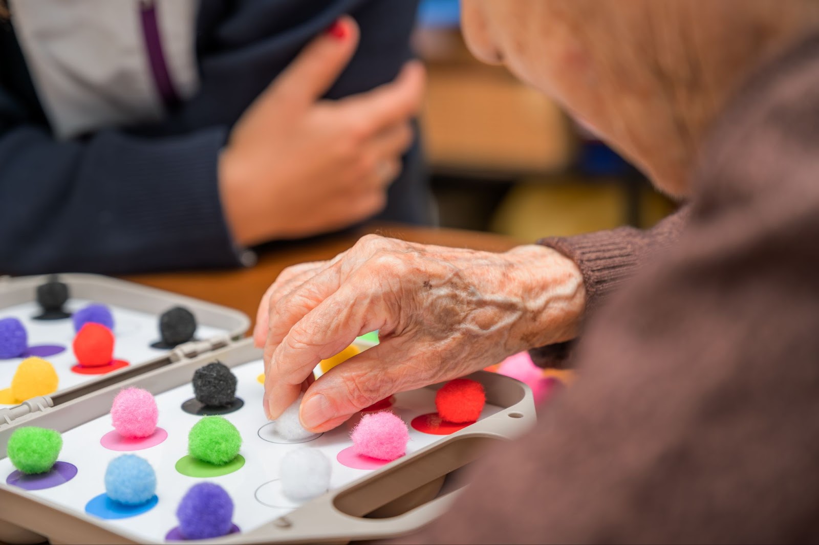 a close-up of an older person utilizing a memory supporting activity offered by their memory care community.