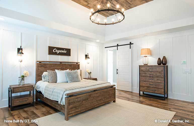 Primary bedroom with natural wood furnishings and a barn door that opens to the primary bath.